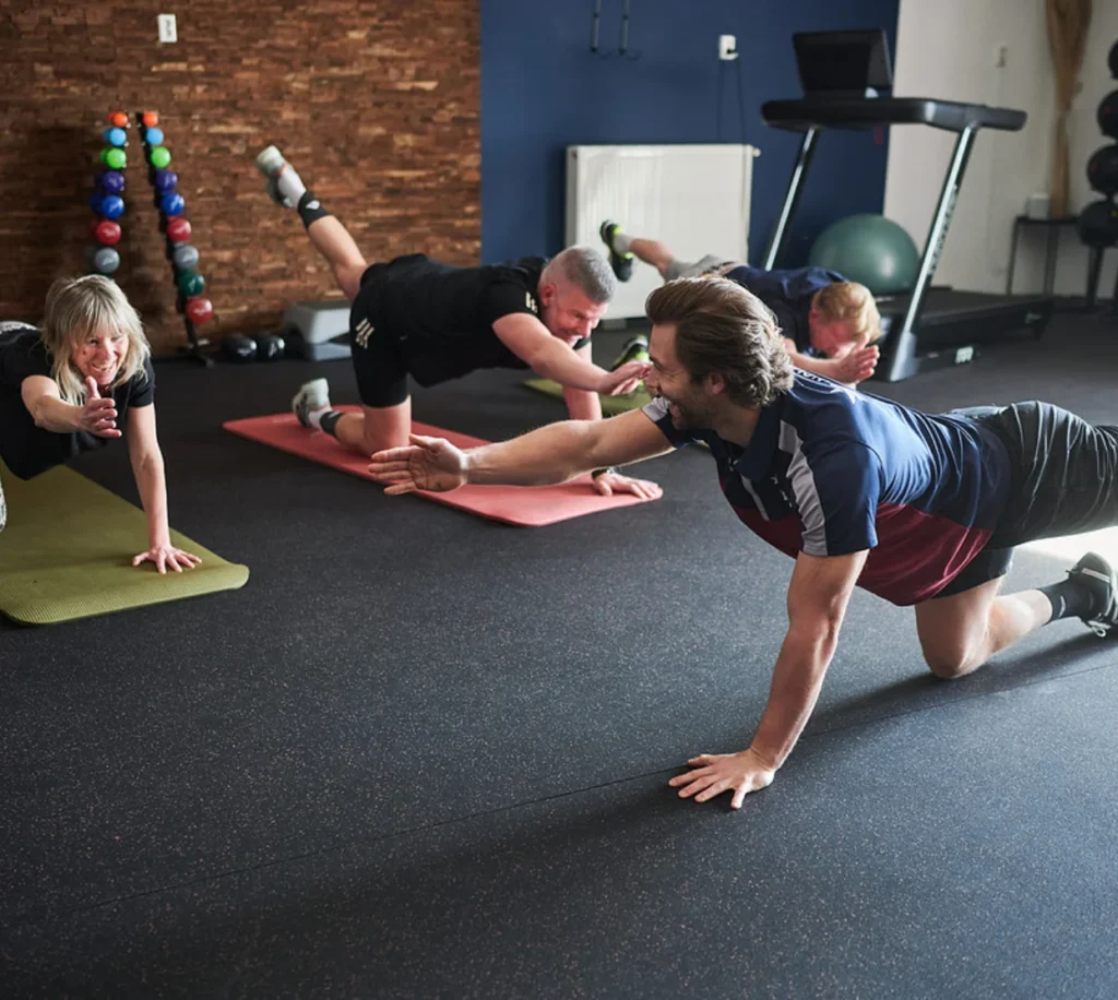 Groep mensen doet begeleide oefeningen in de huidige NOVAFIT-trainingsruimte