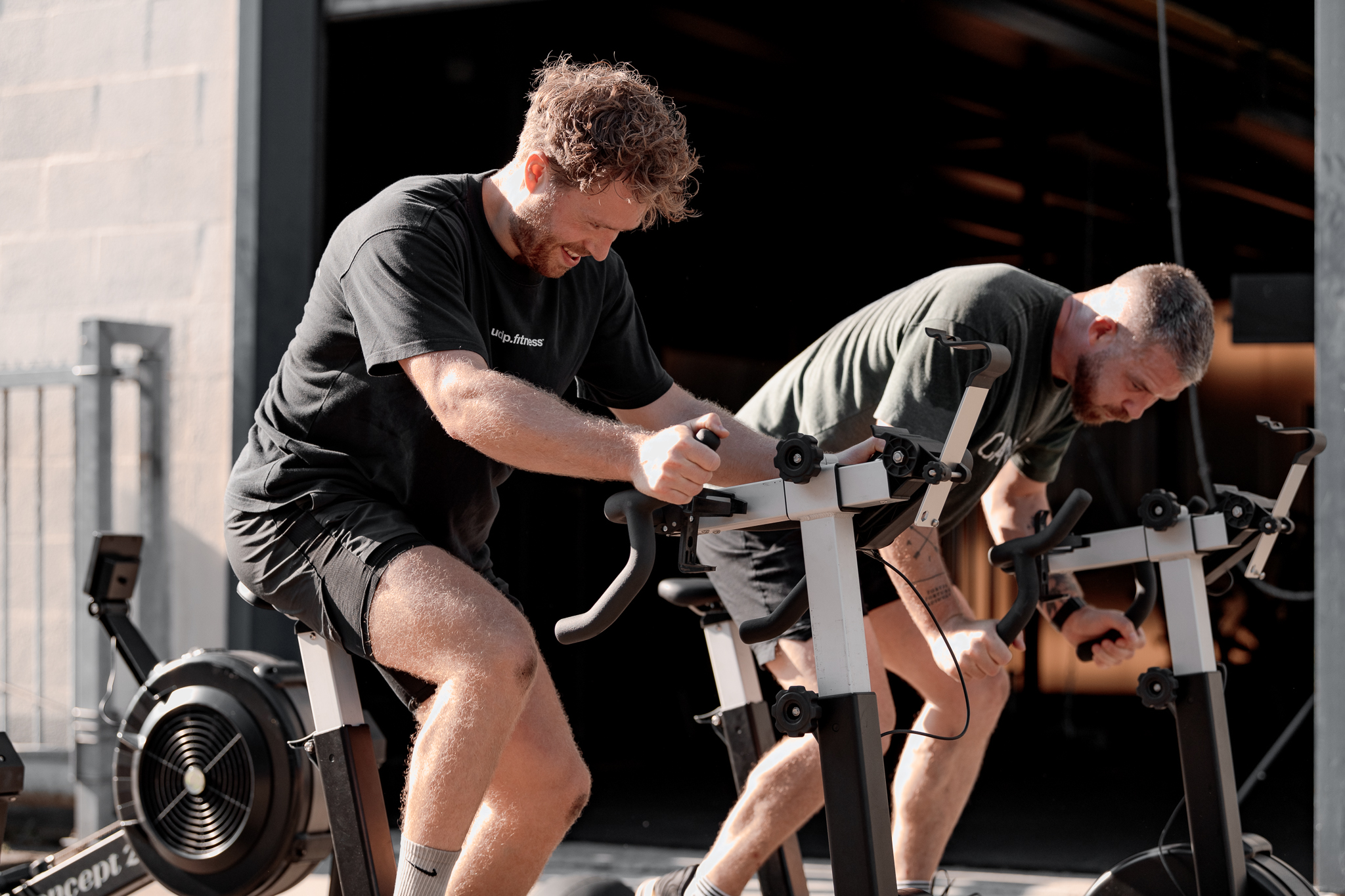 Twee sporters op roeimachines bij UDP.fitness